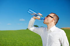 мужчина пьет воду Эталон из бутылки на природе