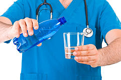 доктор наливает воду из бутылки в стакан